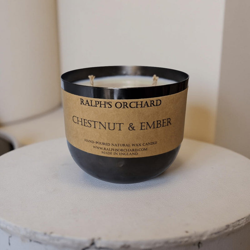 Candle with 'Ralph's Orchard' label on a white surface