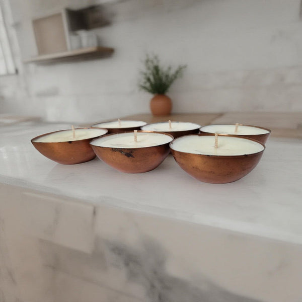 Wooden bowls with candles on a marble surface