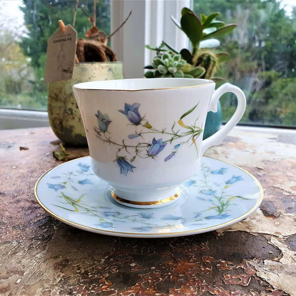 Teacup and saucer with floral design on a wooden surface