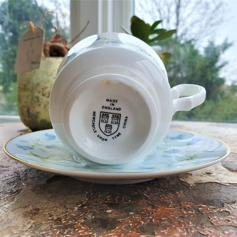 Teacup and saucer with 'Made in England' stamp on a textured surface