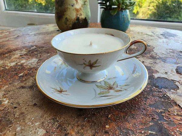 Teacup and saucer with a candle on a textured surface