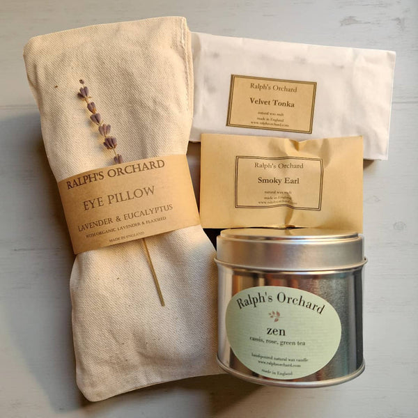Ralph's Orchard eye pillow, tea packaging, and tea canister on a light background