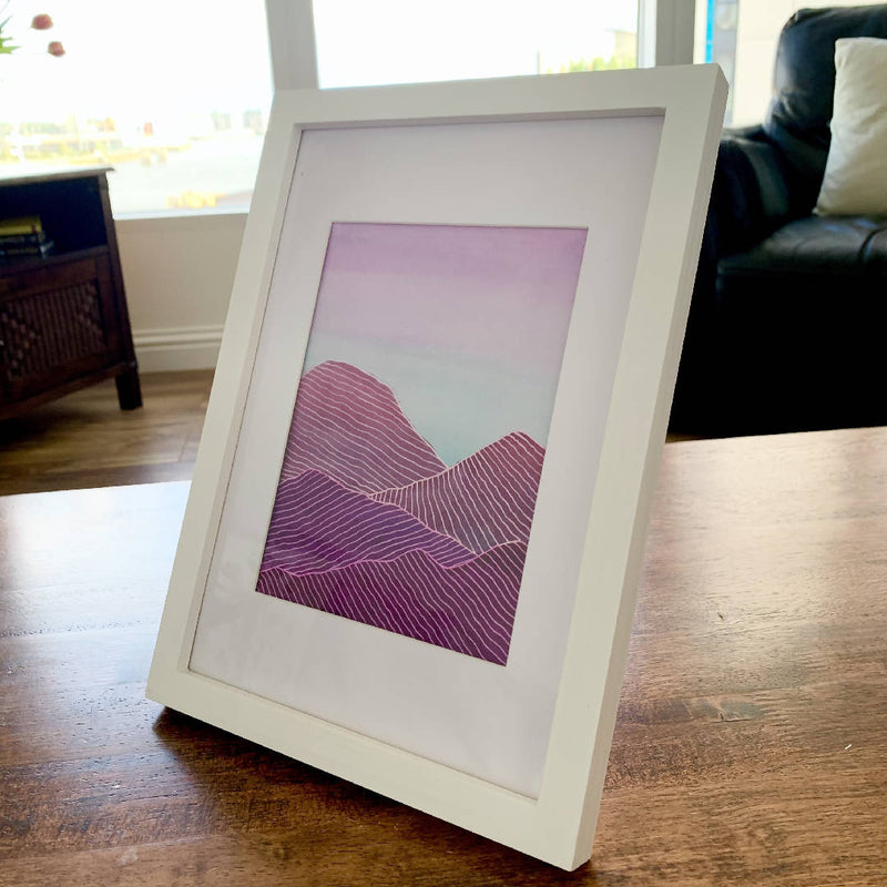 Pink Violet Blue Watercolour White Ink Mountains Painting Wall Decor in a White Wooden Frame