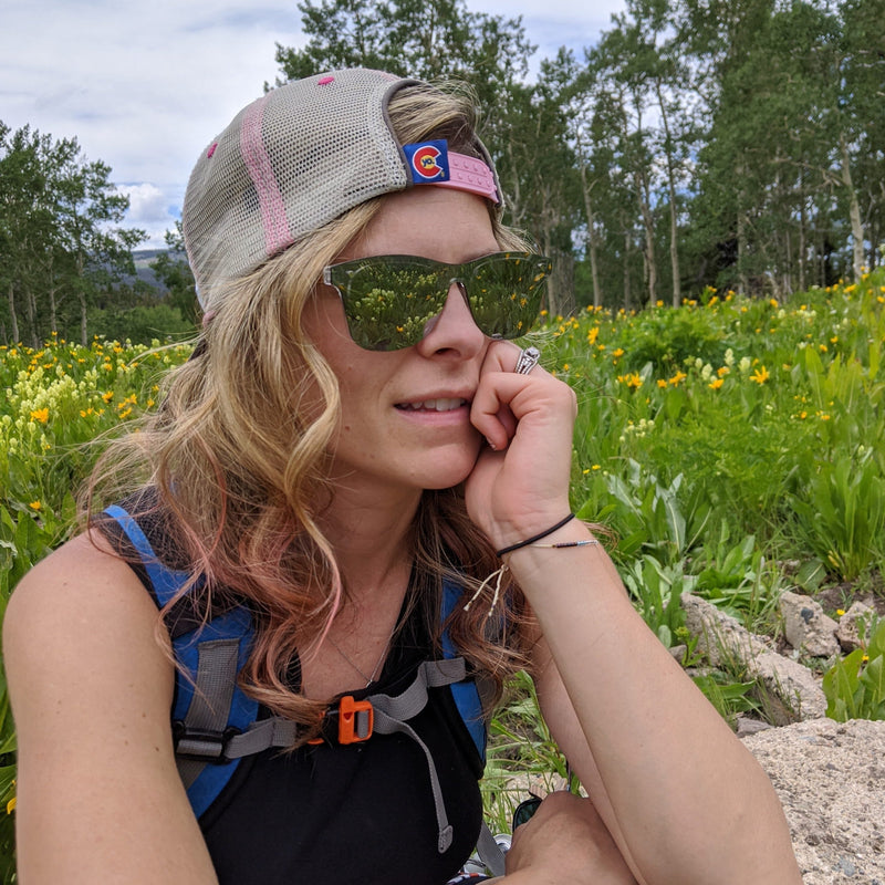 Danelle contemplating hiking in the woods wearing her mirror SAARA shades