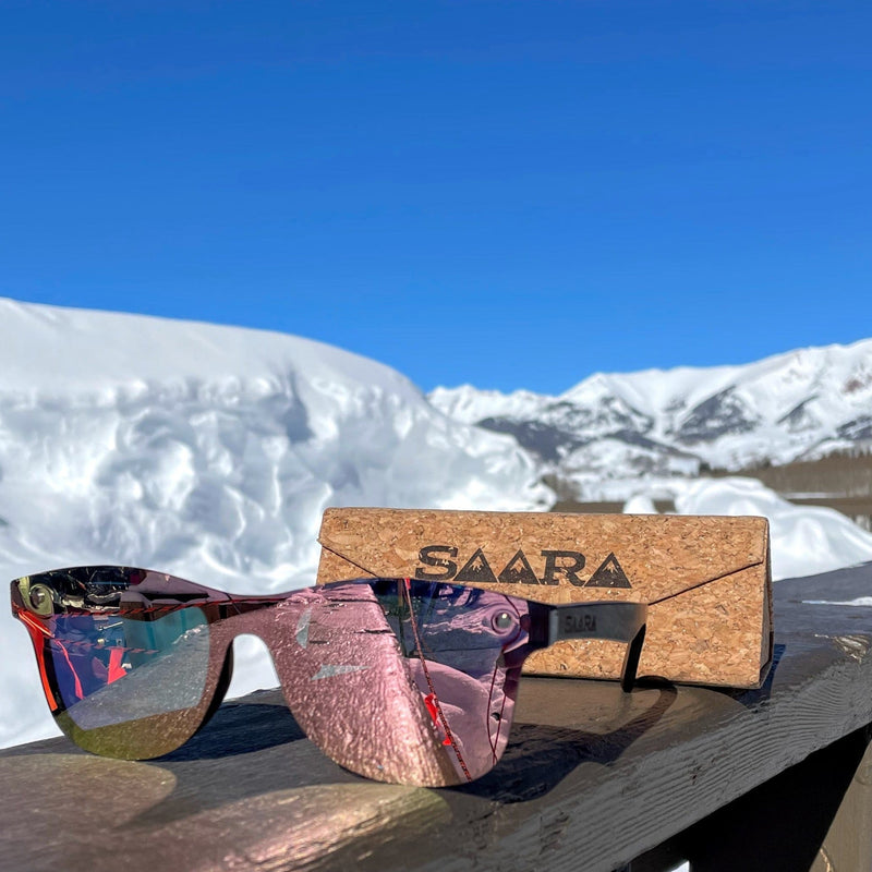 Rose gold SAARA shades with a cork foldable case and the colorado mountains in the background