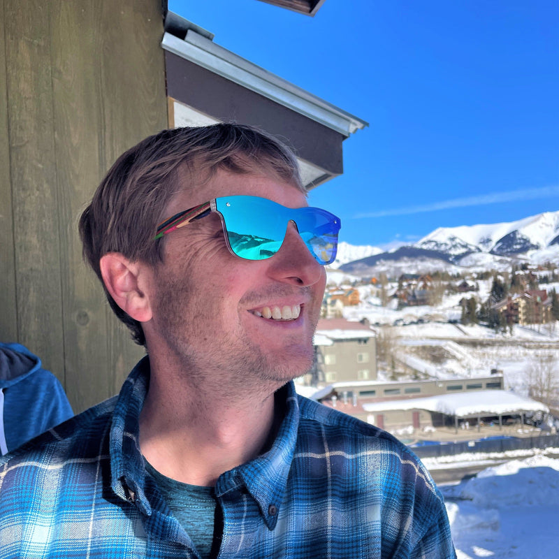 Brent staring out to the mountain with mountains in the background wearing emrald sky rainbow SAARA shades in Crested Butte Colorado